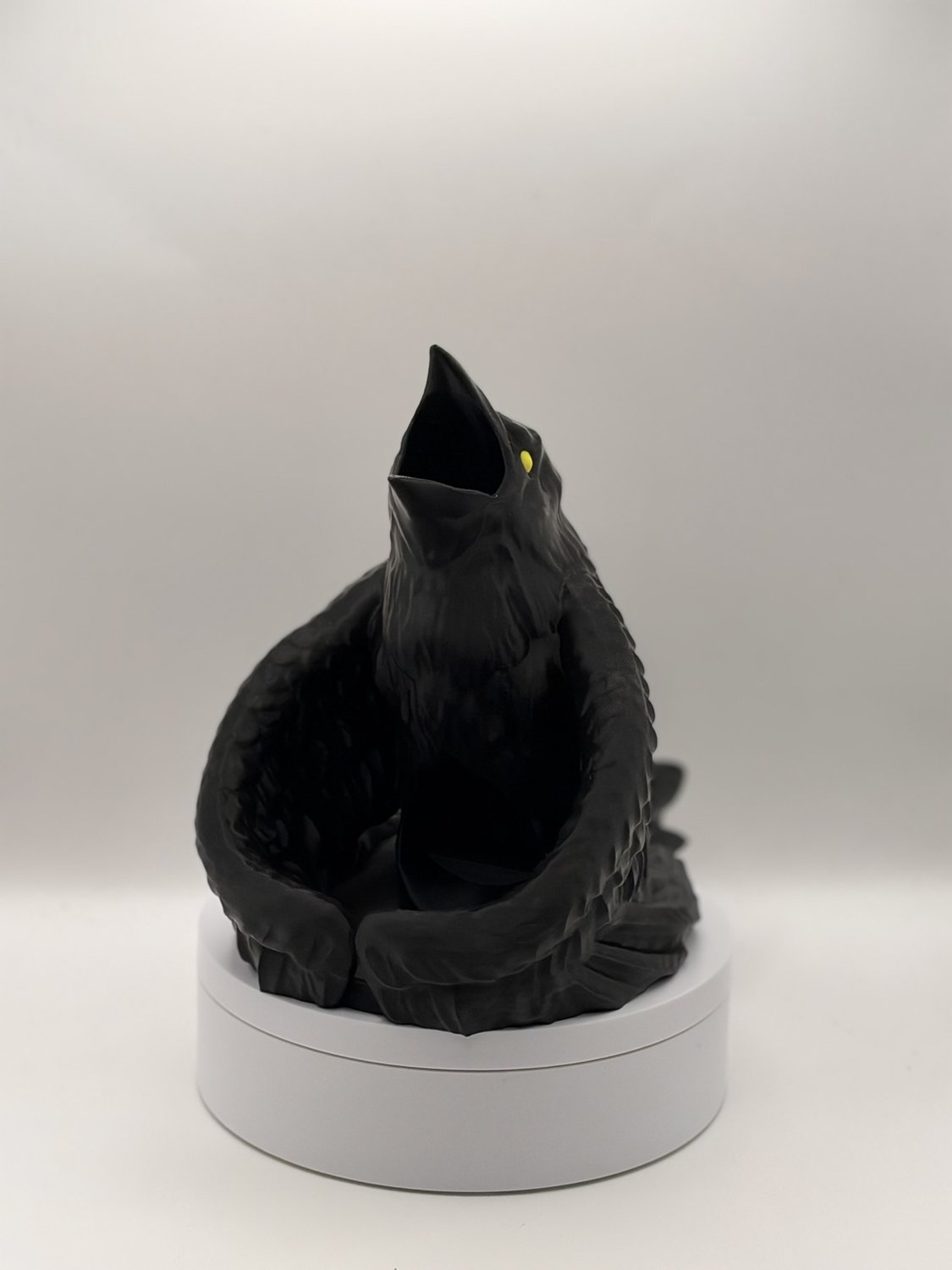 Close front view of gothic black raven dice tower showing wings and open mouth